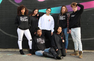 students standing in front of wall art