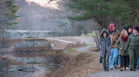 students walking down path near mill