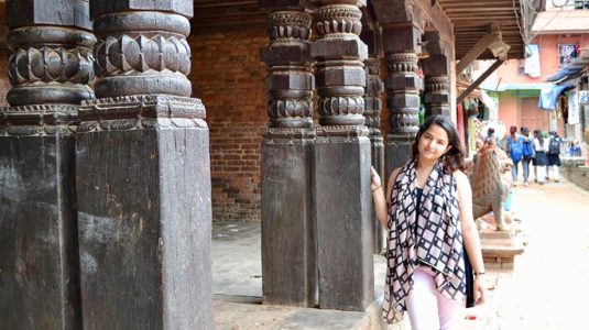 Sweta Basnet standing next to stone ruins