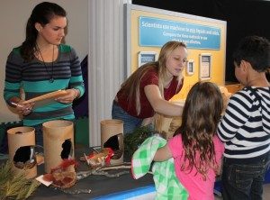 Sarah MacLachlan '14 and Savannah Sanford '17 watch as museum patrons guess city bird habitats