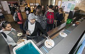 Students put their empty plates on the Higgins Cafe dish belt.