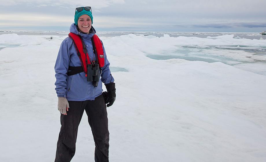 Meghan Kelly, a graduate student at Clark University, standing on land in the Arctic.