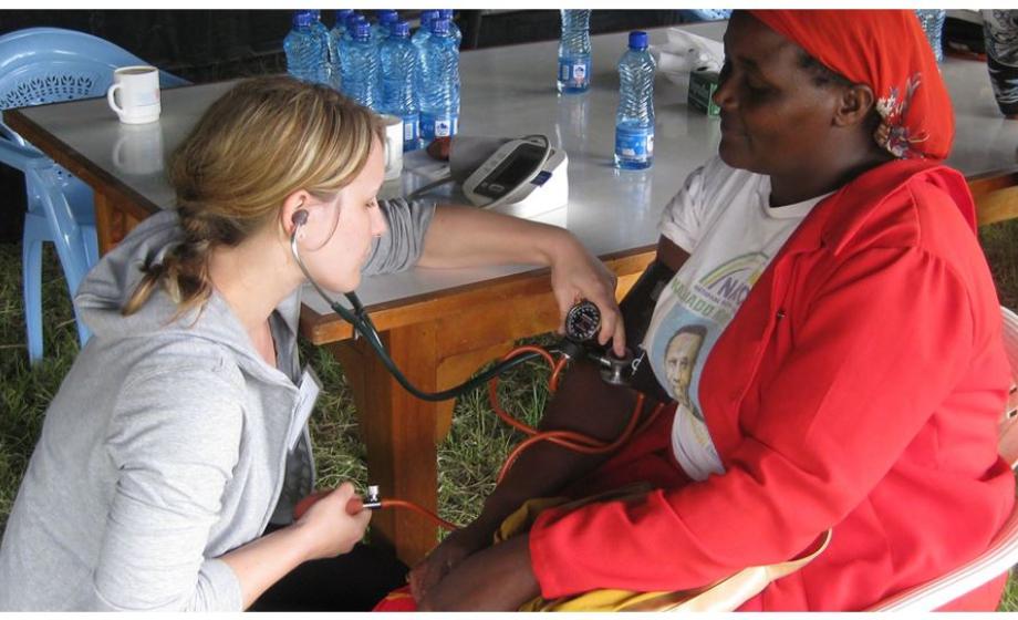 clark student checking pulse on african woman in clinic