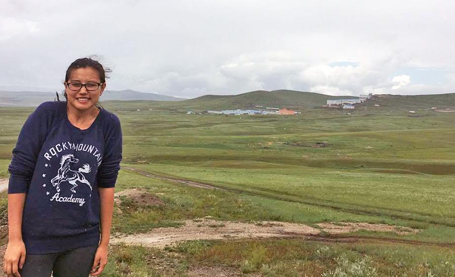 Odgerel Chintulga outside in Mongolia, with mountains in background