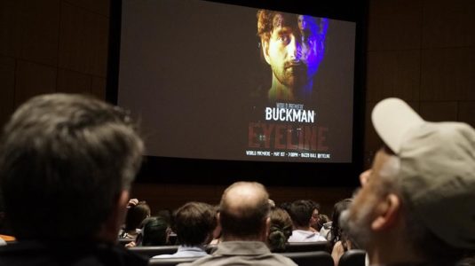 people sitting in audience looking at presentation