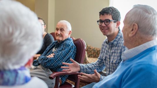 Jeremy Maltz ’20, right, listens to retirees describe their technology experience; at left is alumnus Kenneth Hedenburg '50, who has a degree in business administration from Clark.