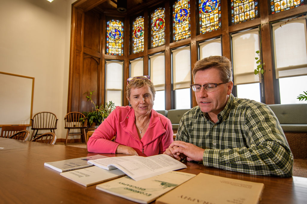 James Murphy and Hilary Laraba sitting at table looking at journal