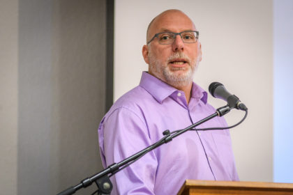 Ken MacLean speaks at lectern