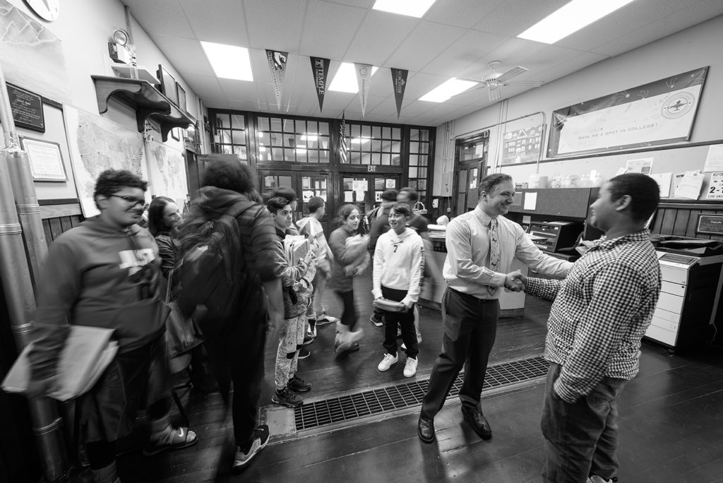 Principal Dan St. Louis ’00, M.A.Ed. ’01, greets students at the University Park Campus School,