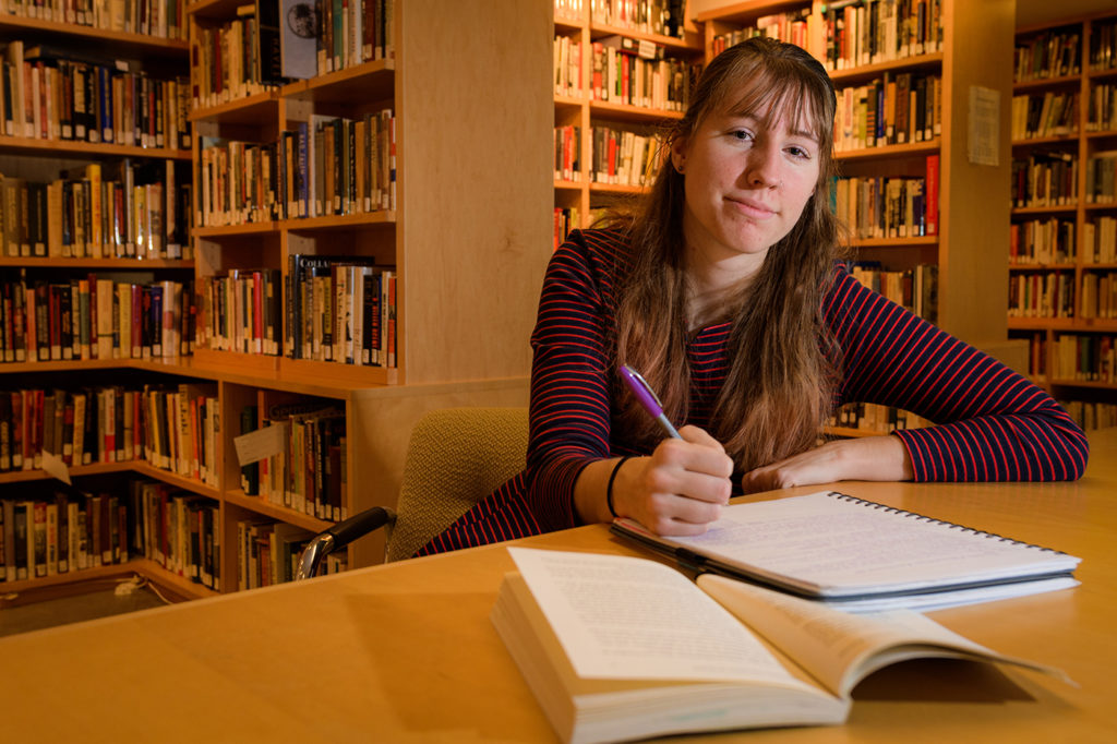 Casey Bush in front of bookshelves