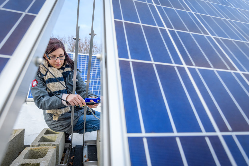 Megan McIntyre works on a solar panel