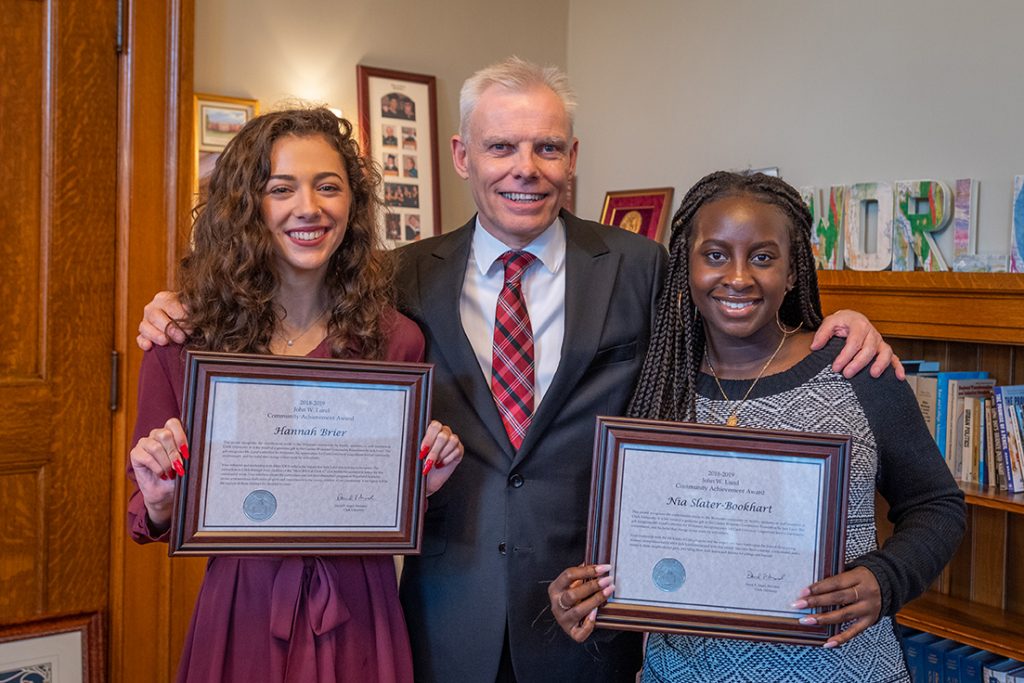 President David Angel presents Lund awards to Hannah Brier ’20, left, and Nia Slater-Bookhart ’19.