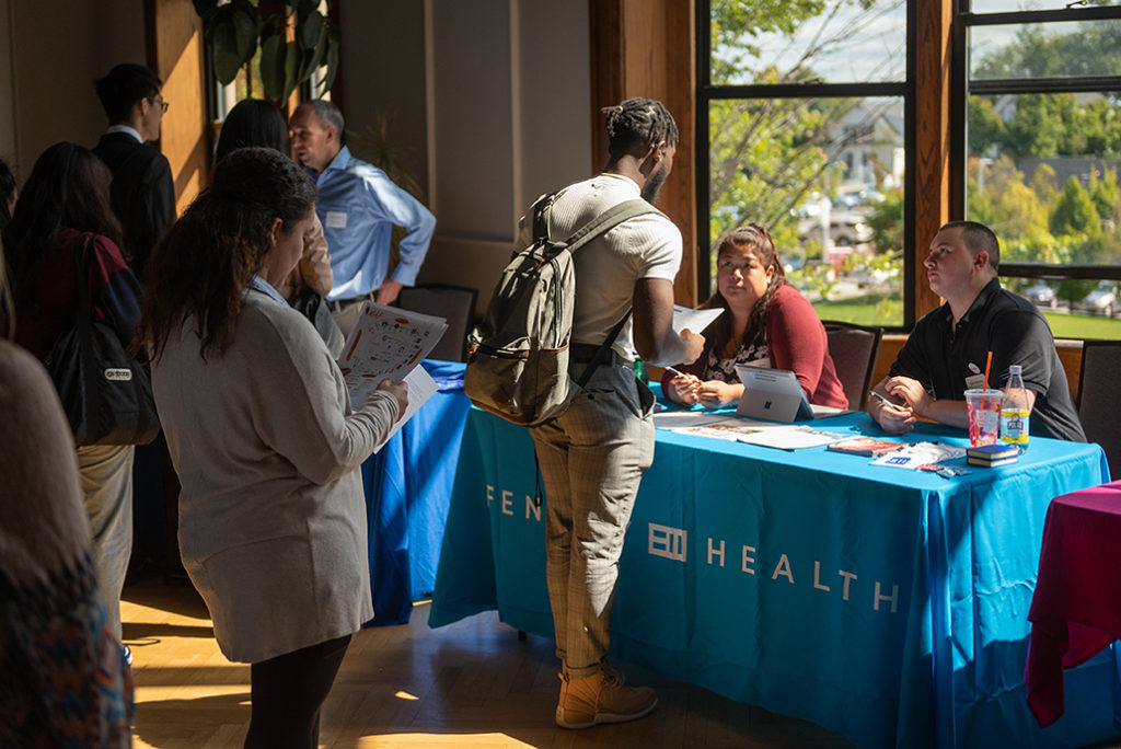 Student attending career fair talks to employer representatives