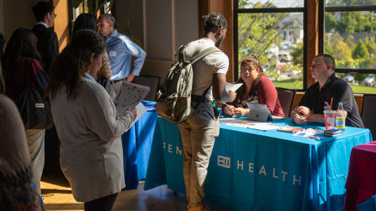 Student attending career fair talks to employer representatives