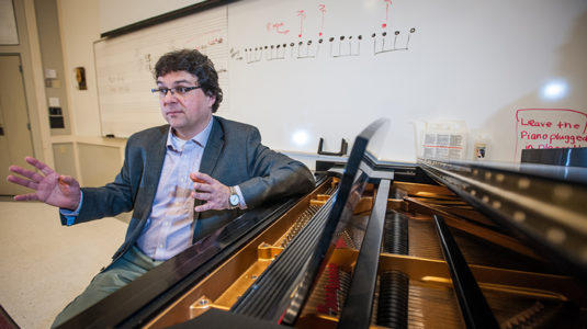 Professor Ben Korstvedt sits at the piano