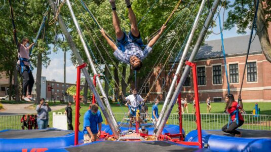 students jump on bungee trampolines