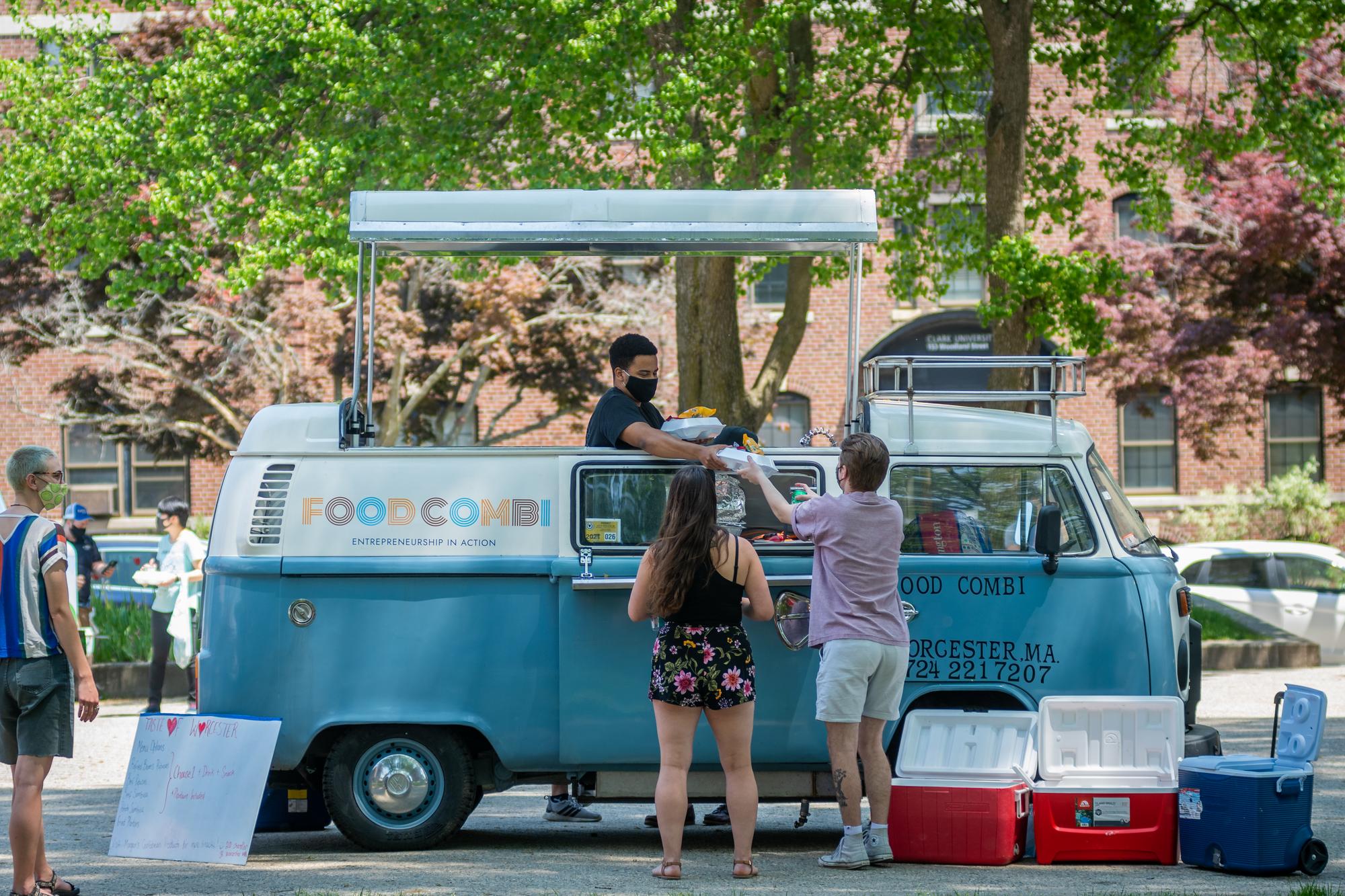 students serve food from a Volkswagen food truck