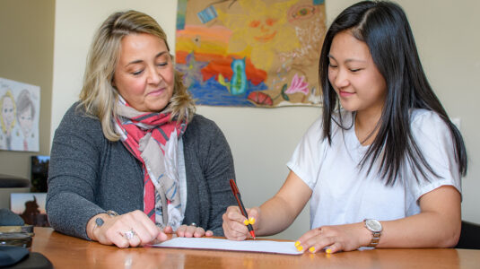 Jessica Bane Robert, director of prestigious fellowships and scholarships (left), works with a Clark student in her office.