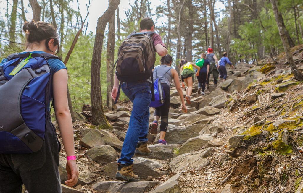 Student's in Clark's Outing Club climb a rocky hill during a hike