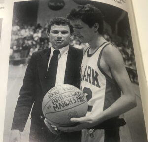 In this photo from the 1983 Clark yearbook, Dan Trant receives the game ball from Wally Halas after scoring his 1,000th career point.