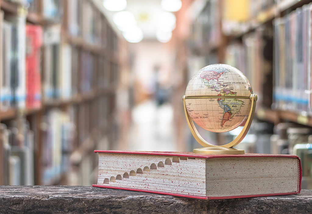 Globe sitting on top of book in academic library