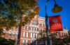 jonas clark hall with red clark university flag in foreground