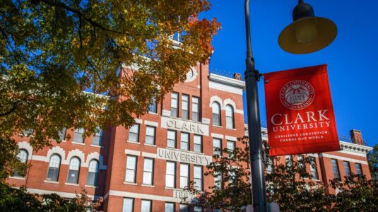 jonas clark hall with red clark university flag in foreground