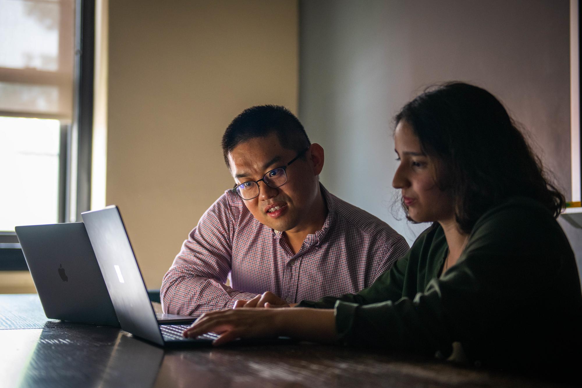 Shuo Niu and Ava Bartolome sit at a laptop