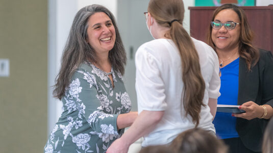 Professor Laurie Ross (left) and Professor Jennifer Safford-Farquharson congratulation a Youth Worker Training Institute graduate.