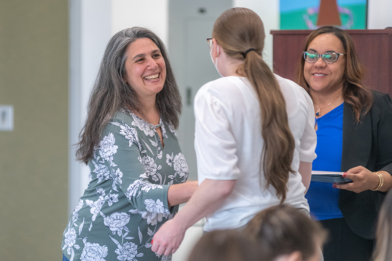 Professor Laurie Ross (left) and Professor Jennifer Safford-Farquharson congratulation a Youth Worker Training Institute graduate.