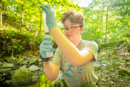 student collects water sample