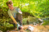 student collects water sample