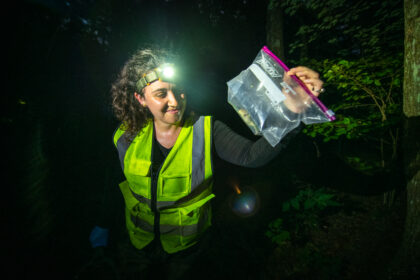 student holding frog in pastic bag