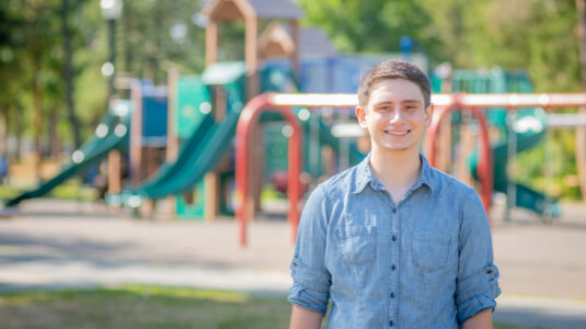 student at park with playground