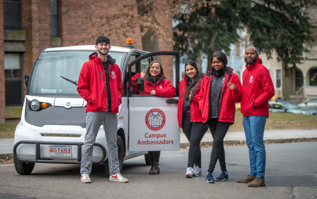 Clark University Campus Ambassadors with their campus vehicle 