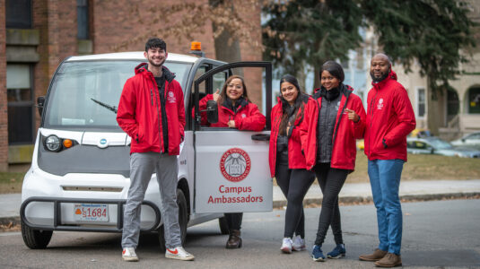 Clark University Campus Ambassadors with their campus vehicle