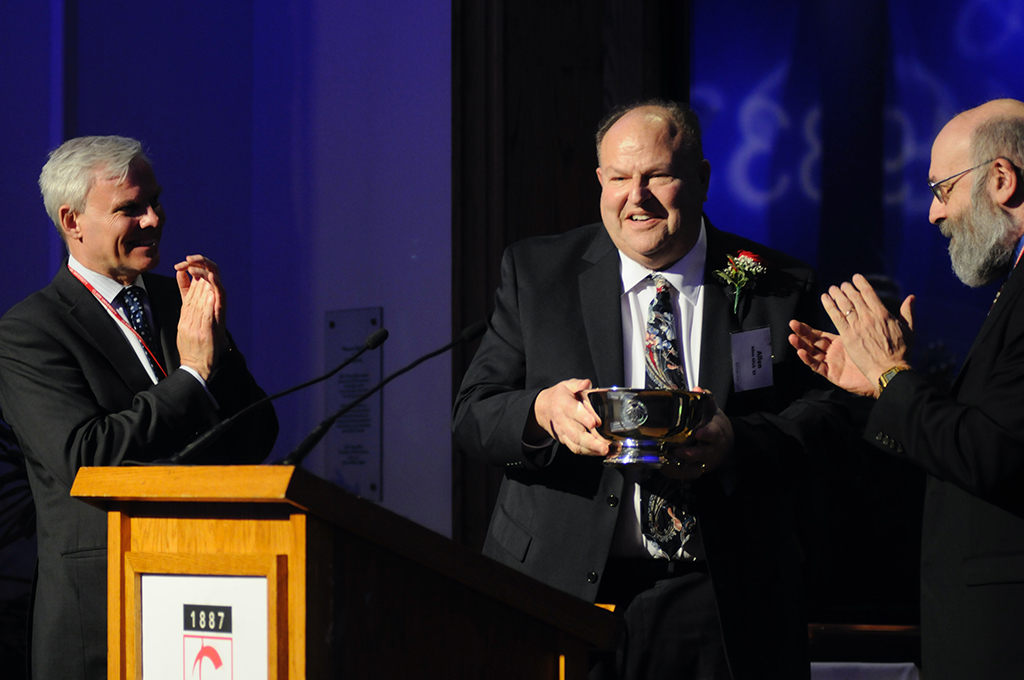 Allen Glick (center) is presented with the Distinguished Alumni Award by then-President David Angel (left) and Professor Everett Fox. 