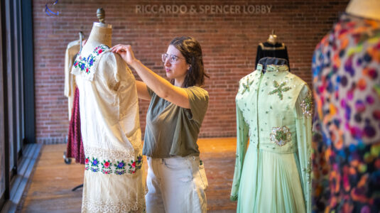 Maia Snyder '23, M.A '24, arranges a historic fashion exhibit on campus.