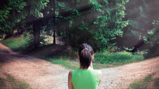 Woman standing at fork in the road