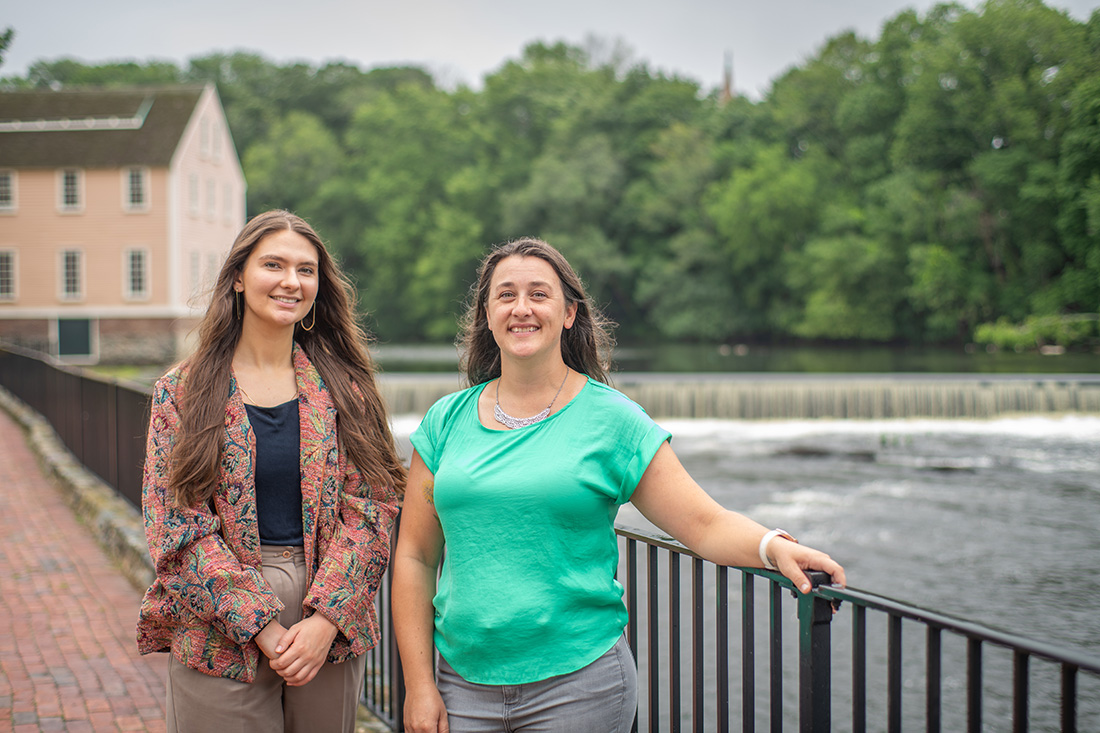 Stephanie Covino, M.S. ’15 (r.), manager of the Blackstone Watershed Collaborative, and Caleigh McLaren ’22, M.S. ’23, restoration coordinator for the Collaborative, at the Slater Mill Dam.