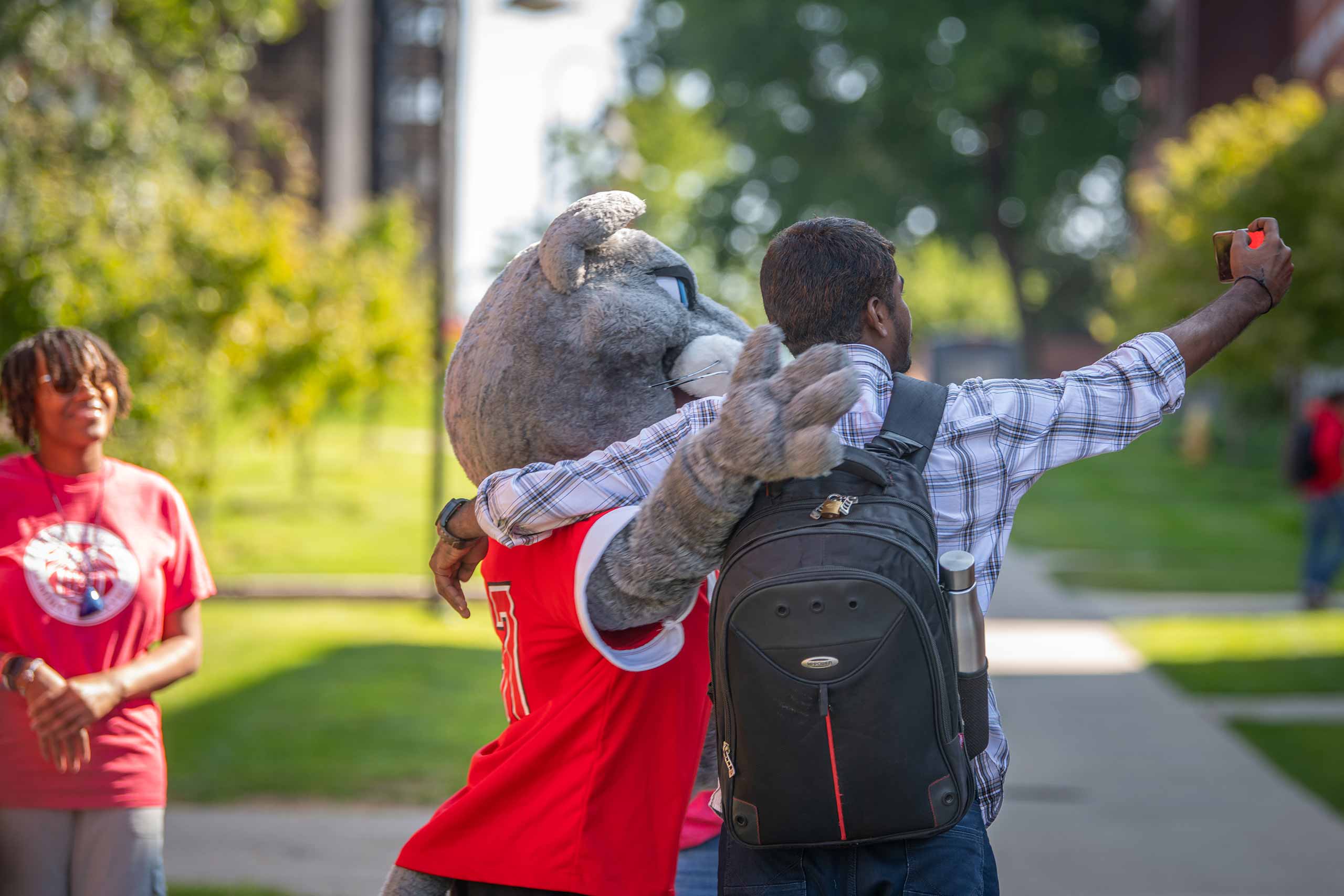 A student taking a selfie with the cougar mascot