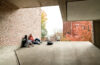 Students sitting against brick wall