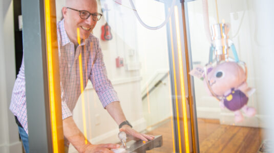 Gary Goldberger, president of Fablevision, plays a claw machine game.