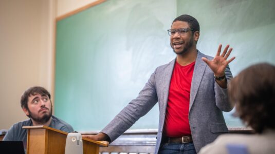 justin shaw teaching students in front of blackboard