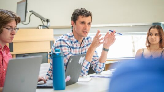 Professor at table with students