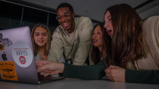 four students with laptops