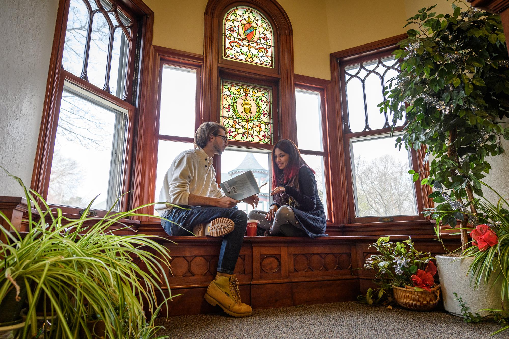 students sitting in front of stained glass window