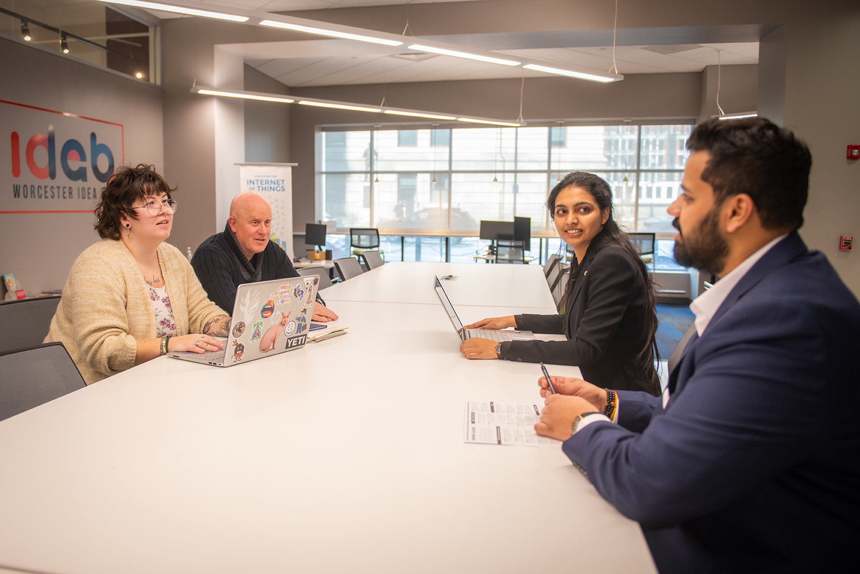 School of Management students Parimala Yerraguntla, M.S. ’25, and Aaryan Pankaj Dabhade, M.A. ’25 (right), meet at the Worcester Idea Lab with Margie Breault, Business & Community Advancement Manager for the City of Worcester in the Office of Economic Development, and Tom Herald, director of the Small Business Development Center at Clark University.