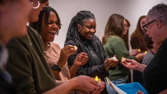 students holding tea lights