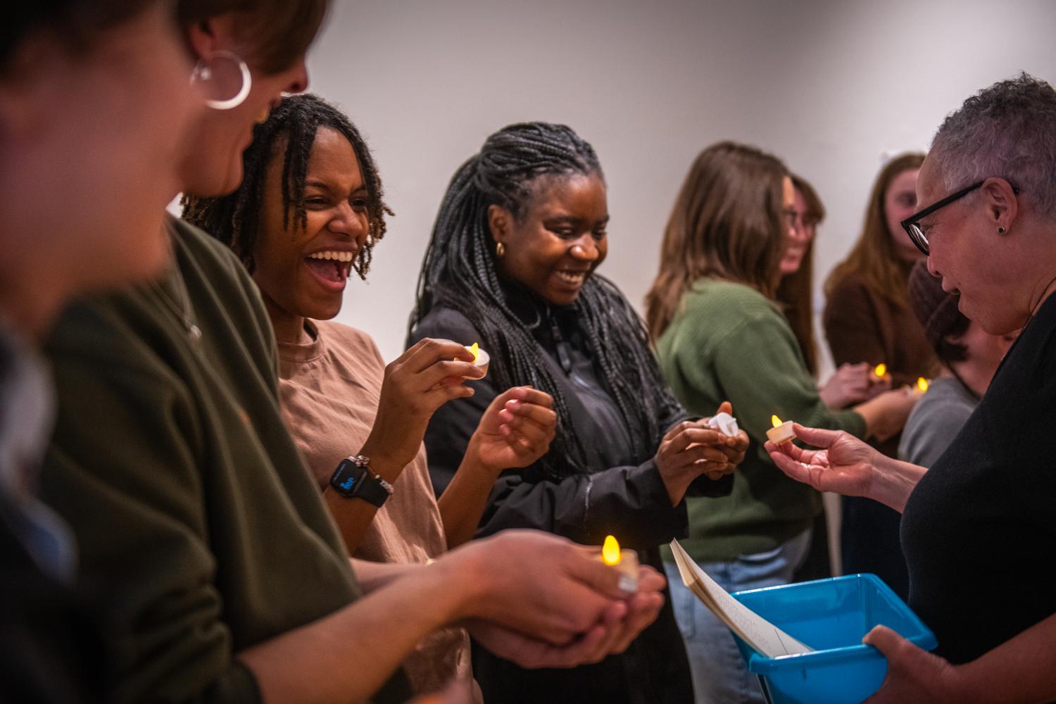 students holding tea lights